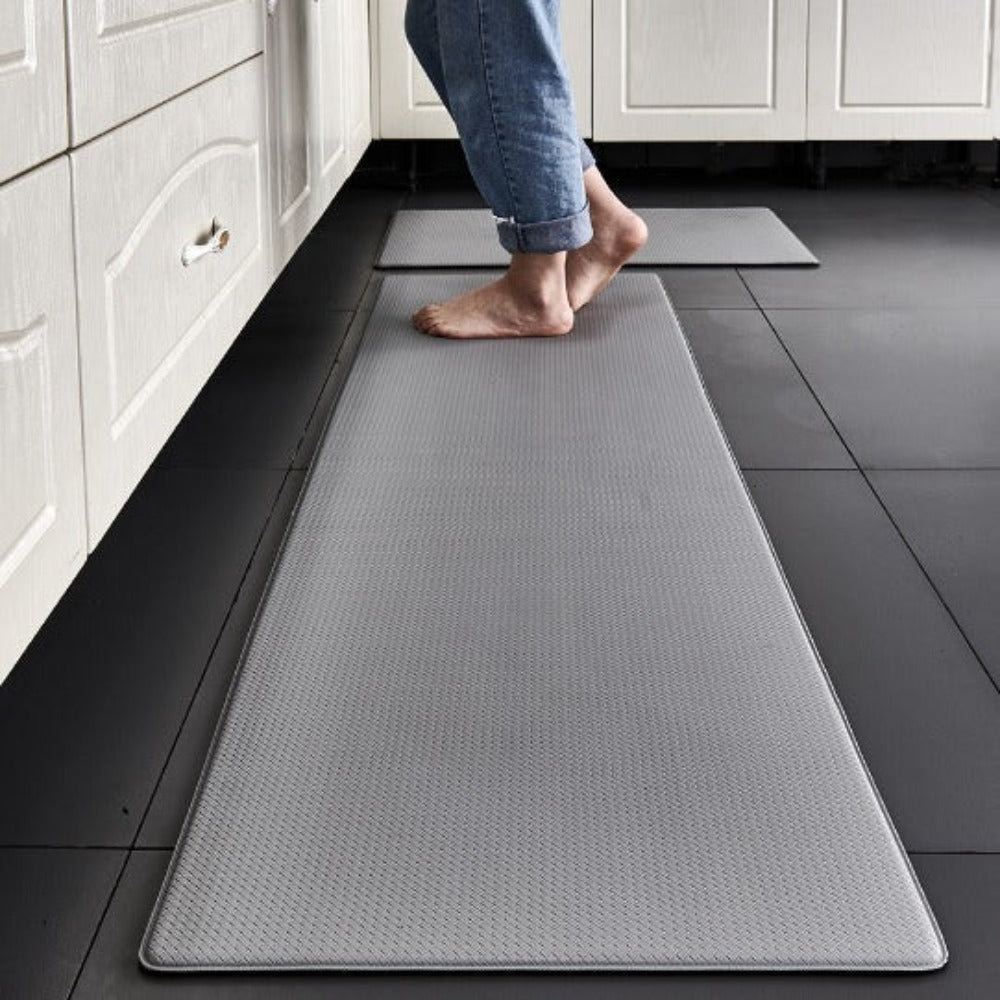 Person walking on a long gray mat in a kitchen setting