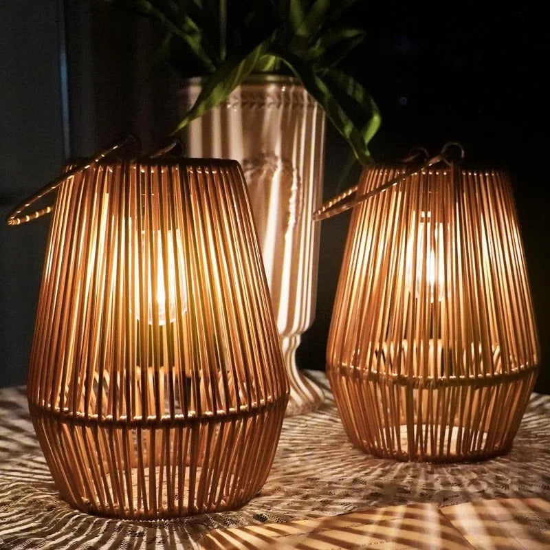 Two illuminated rattan lanterns on a textured surface with a dark background