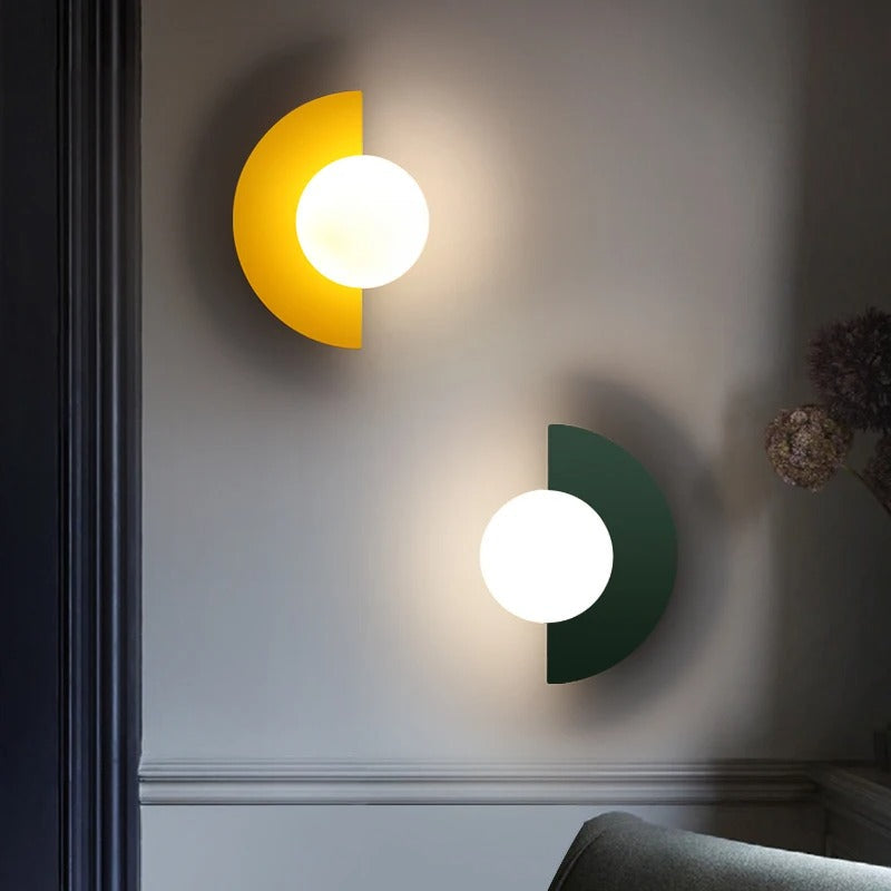 Two wall lights, one yellow and one green, on a gray wall.