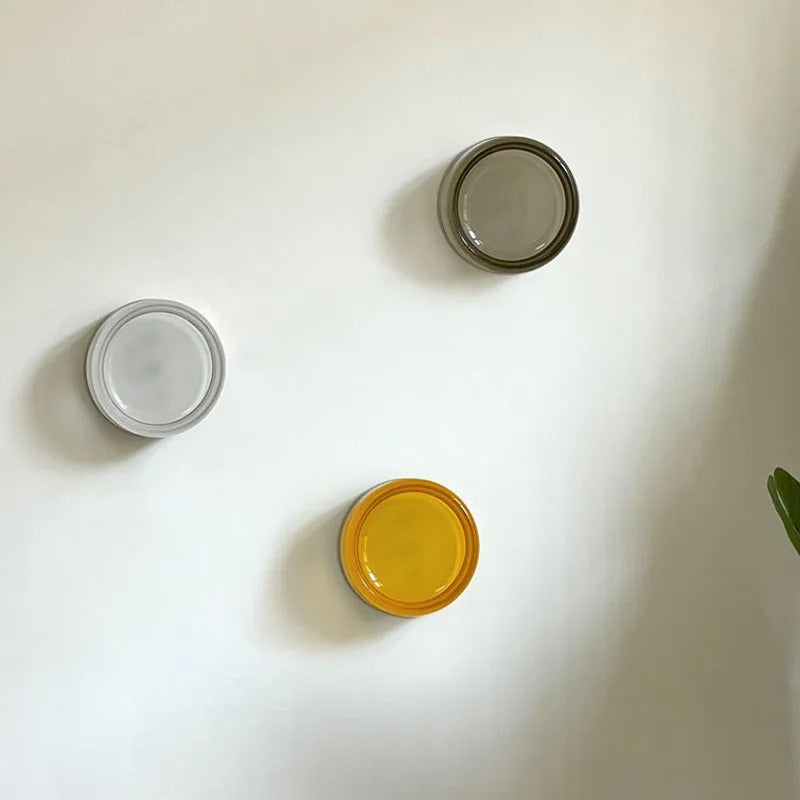 Three colors Round wall light fixture on a textured wall 