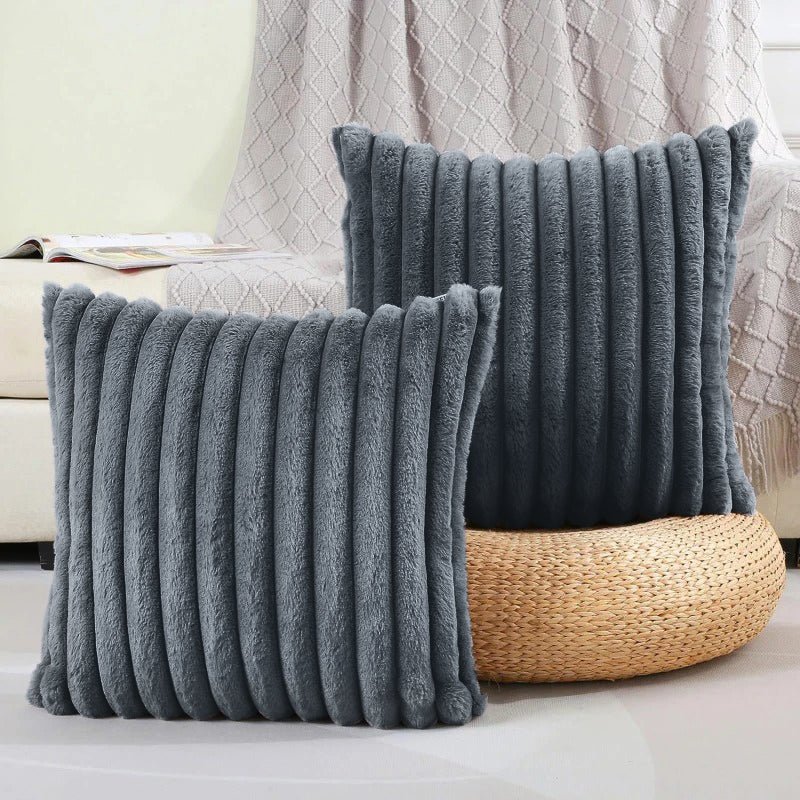 Two gray textured pillows on a couch with a woven basket in the background.