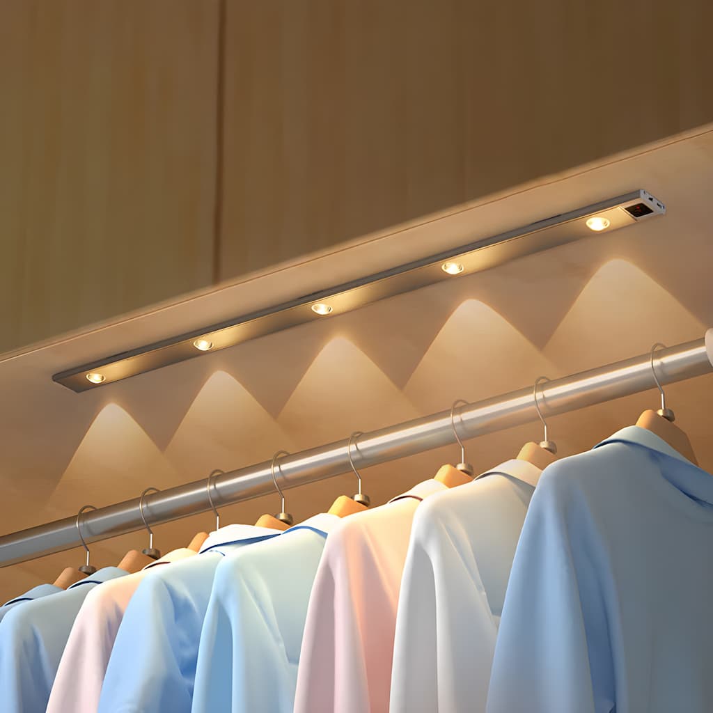 Clothing rack with lights underneath displaying various shirts.