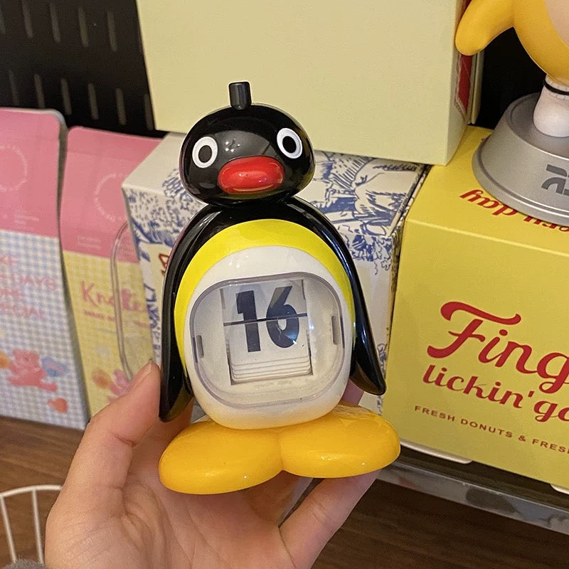 Penguin-shaped calendar held in a hand with a blurred background