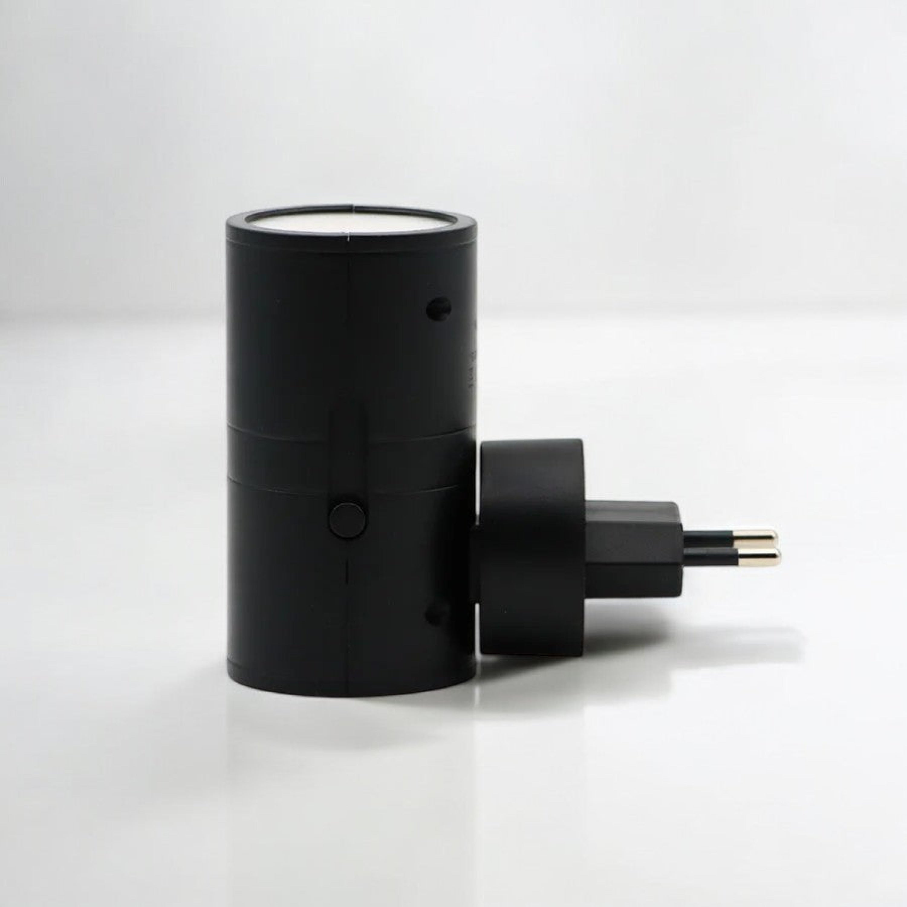 Black cylindrical device with a plug on a white background