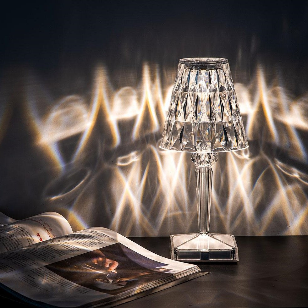 Crystal table lamp on a dark surface with a blurred background