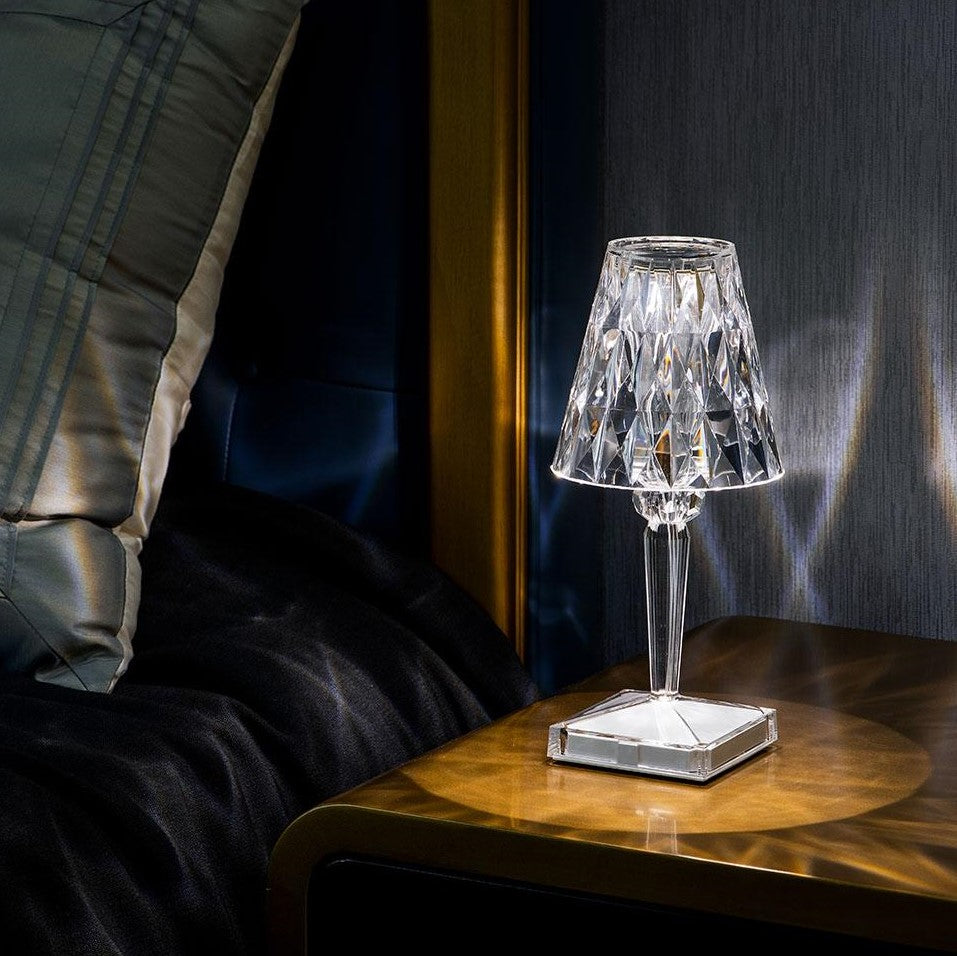 Crystal table lamp on a wooden side table with a dark background