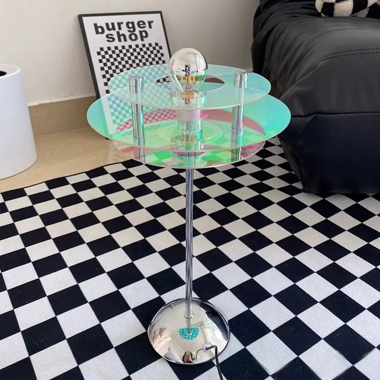 Holographic side table with a unique design on a checkered floor.