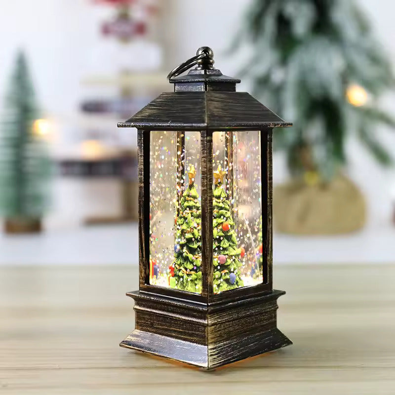 Decorative lantern with a Christmas tree scene inside, on a wooden surface.